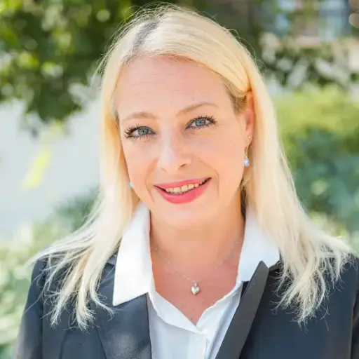Elena Zammit, Visa Officer at Ascencia Malta, smiling outdoors in professional business attire