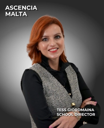 Tess Giordmaina, School Director at Ascencia Malta, smiling with folded arms in professional business attire